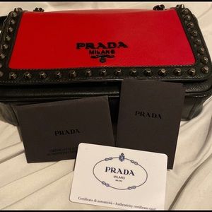 Prada red and black glacé studded trim hand bag.